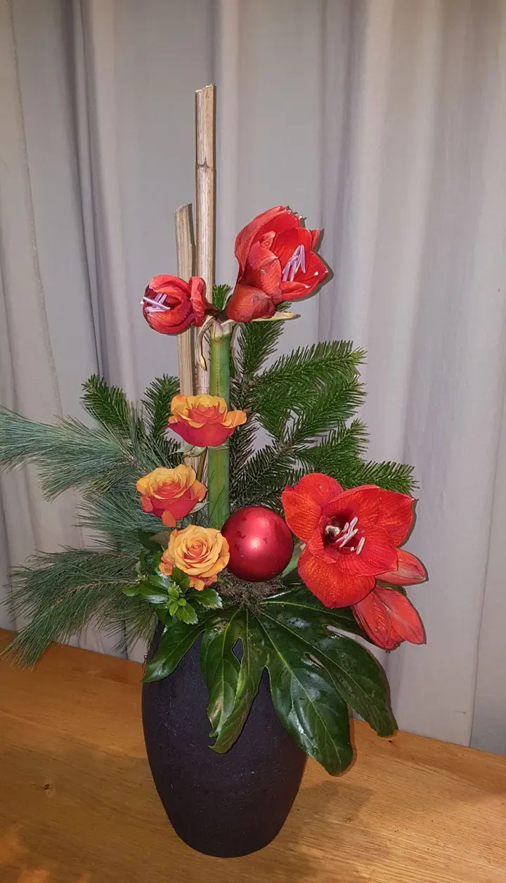 Kerststuk met amaryllis, rozen en dennengroen